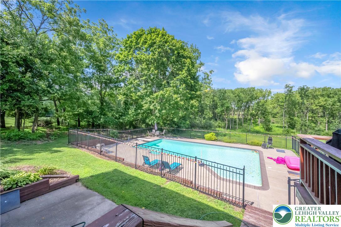 2448 Keeler Road Bath, PA 18014 - Photo 4 of 37 An inviting in-ground pool, securely fenced, promises refreshing enjoyment amidst lush natural surroundings.