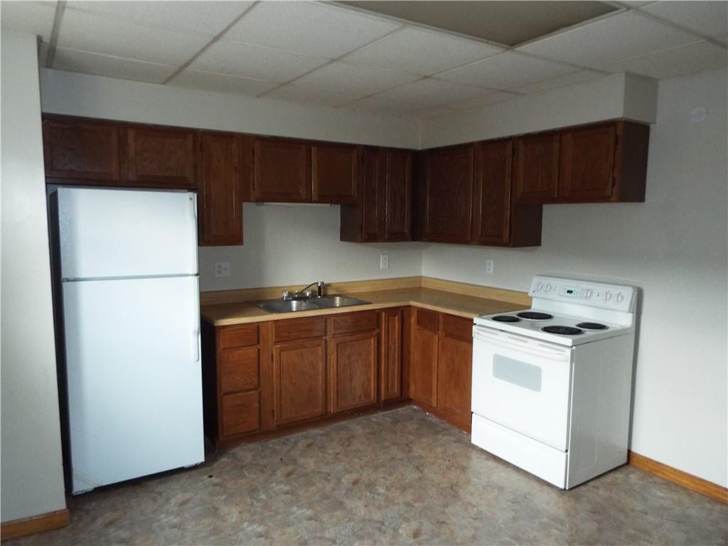 559 Schoonmaker Avenue Monessen, PA 15062 - Photo 14 of 50 a kitchen with a stove top oven a sink and a refrigerator