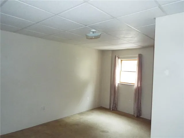 a view of an empty room with closet and a window