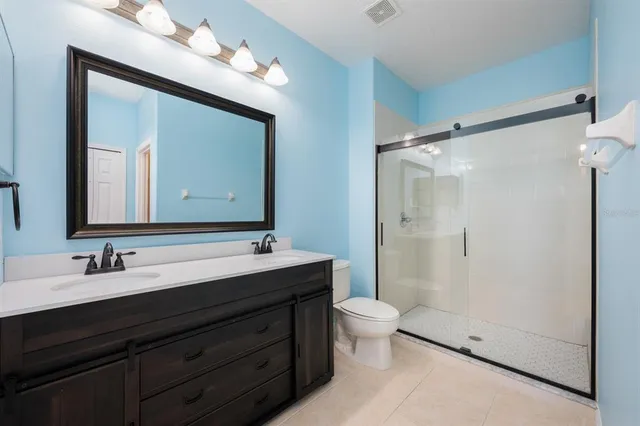 a bathroom with a double vanity sink mirror double and shower
