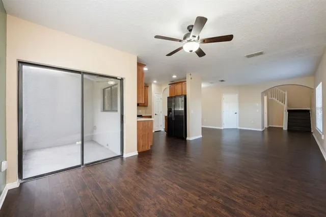 a view of a hallway with wooden floor and a kitchen