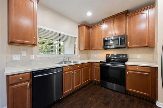 a kitchen with stainless steel appliances granite countertop a stove a sink and a microwave