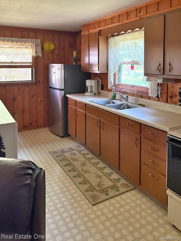 4233 Pheasant Road Lincoln, MI 48742 - Photo 10 of 19 Kitchen featuring wood paneling, wood cabinetry, light countertops
