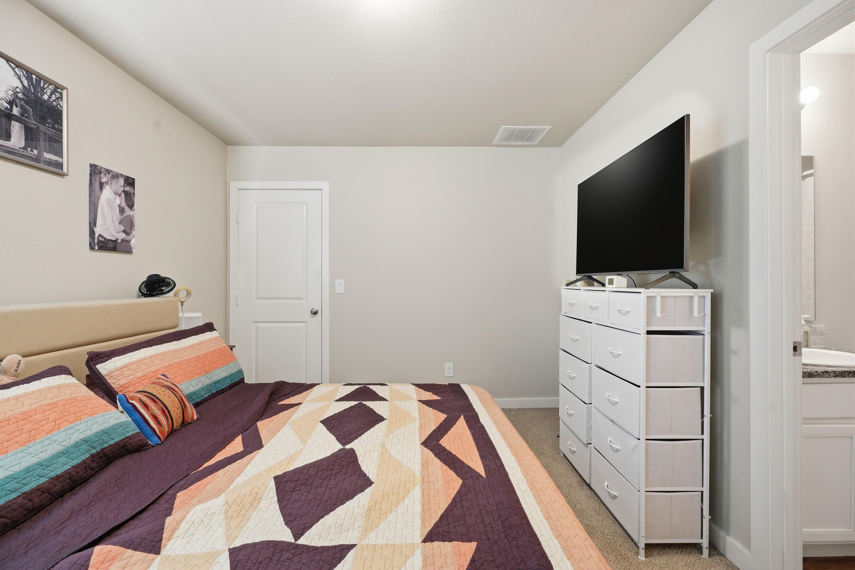 1605 135th Street Lubbock, TX 79423 - Photo 13 of 21 a bedroom with a bed and flat screen tv