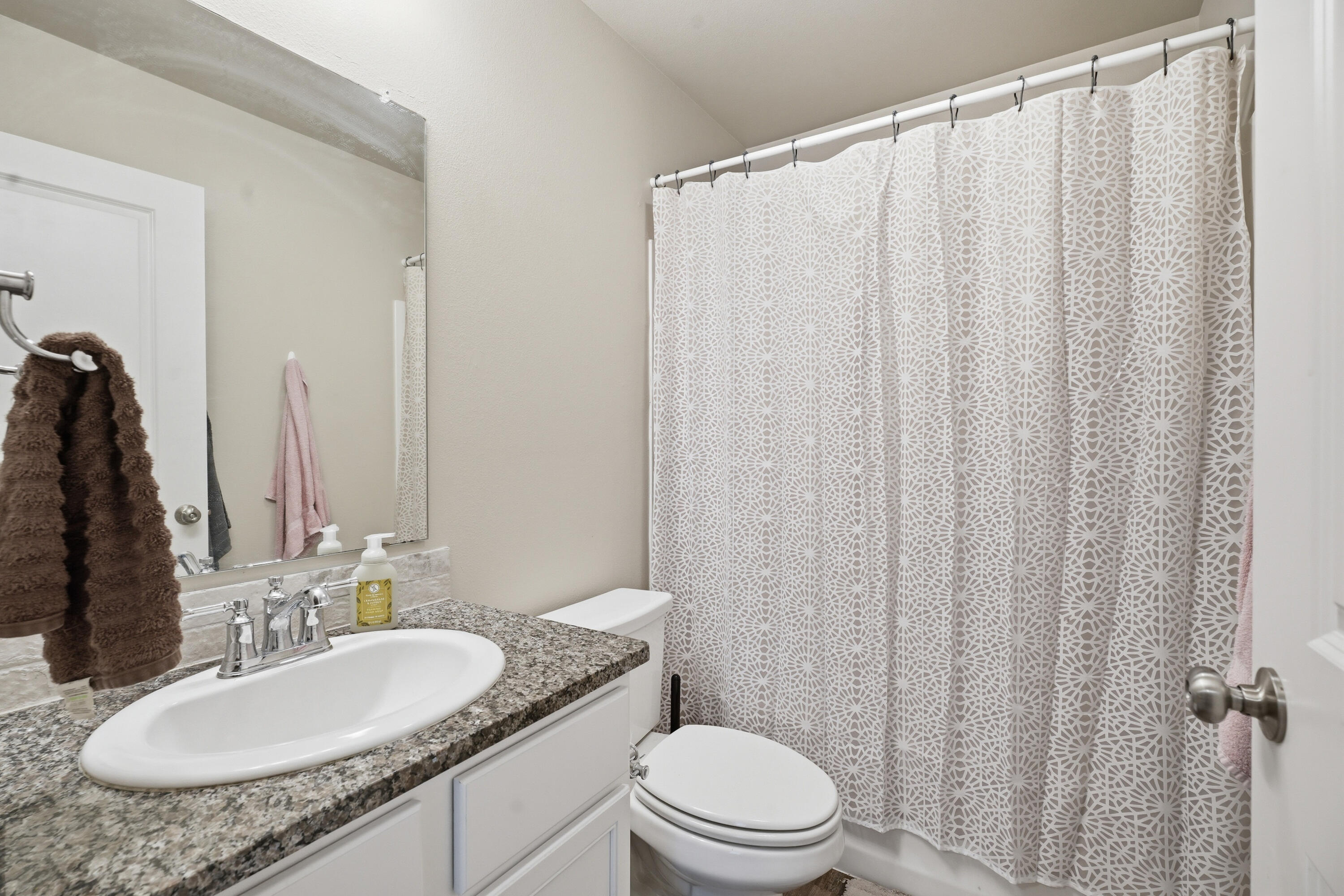 1605 135th Street Lubbock, TX 79423 - Photo 14 of 21 a bathroom with a granite countertop sink toilet and a mirror
