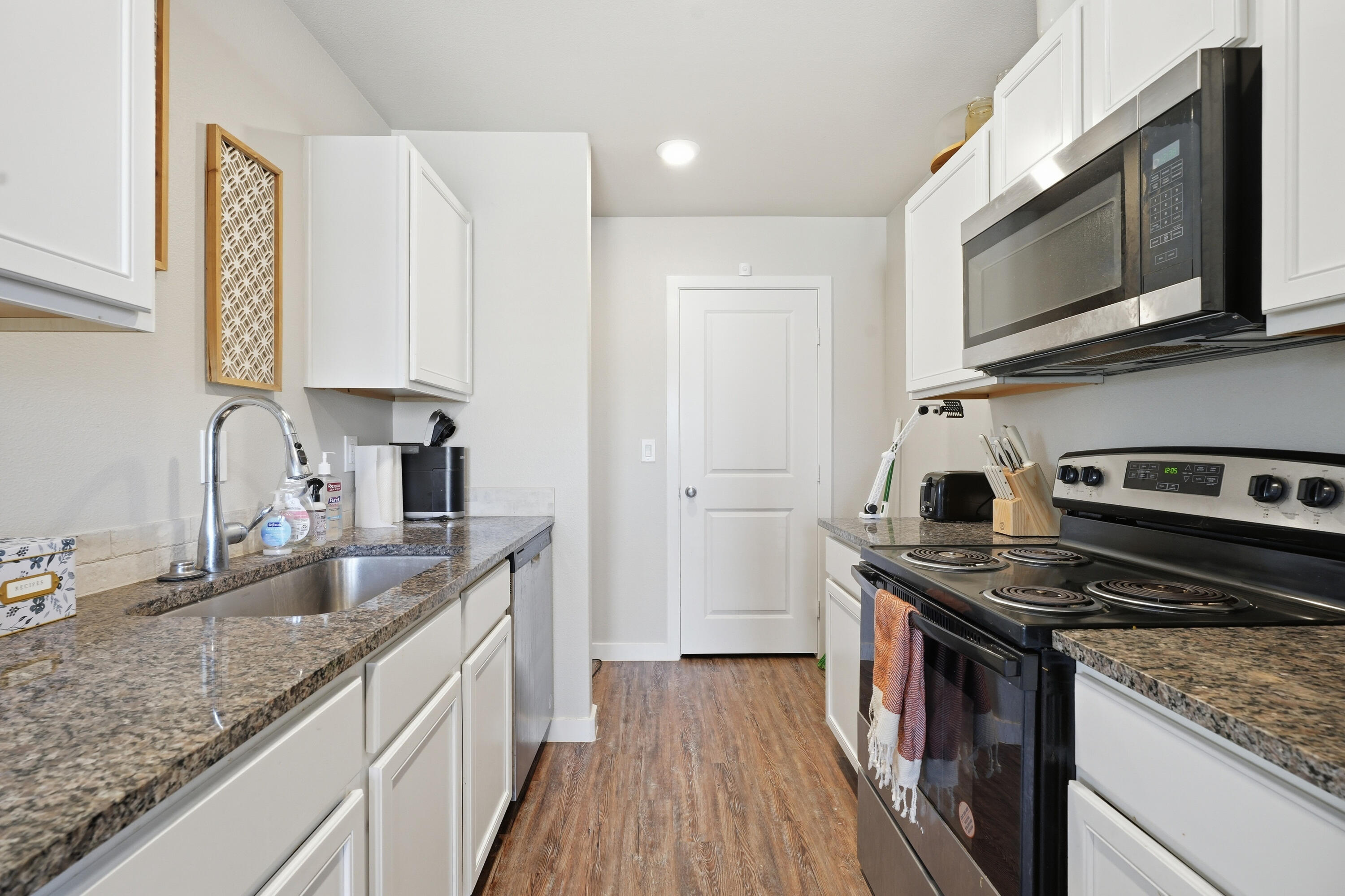 1605 135th Street Lubbock, TX 79423 - Photo 7 of 21 a kitchen with stainless steel appliances granite countertop a stove a sink and a microwave