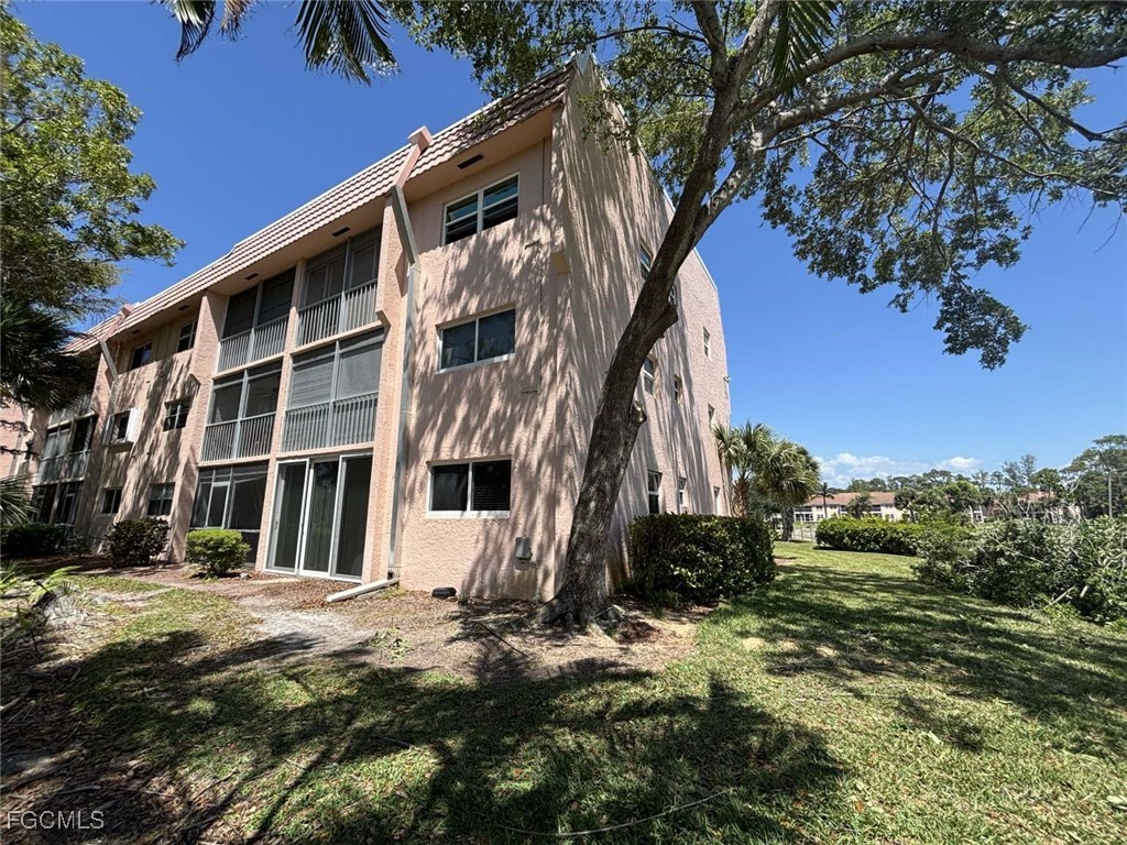 180 Turtle Lake Court, Unit 101 Naples, FL 34105 - Photo 13 of 14 a view of a house with a yard