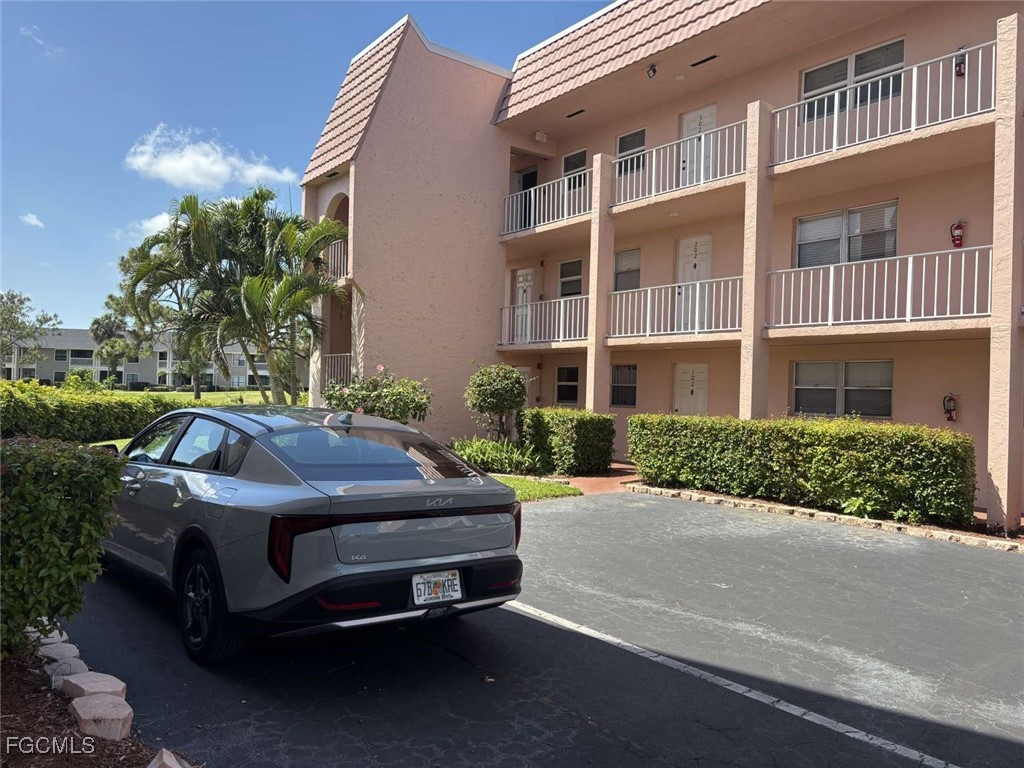 180 Turtle Lake Court, Unit 101 Naples, FL 34105 - Photo 2 of 14 a front view of a house with a garden