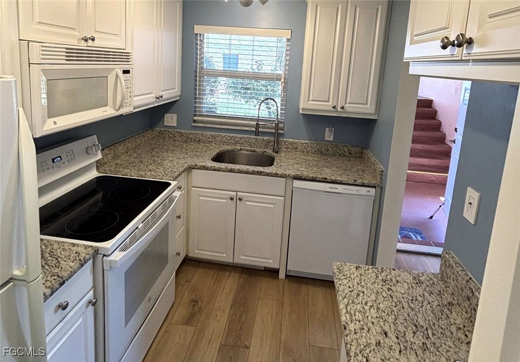 180 Turtle Lake Court, Unit 101 Naples, FL 34105 - Photo 5 of 14 a kitchen with granite countertop a sink and a stove