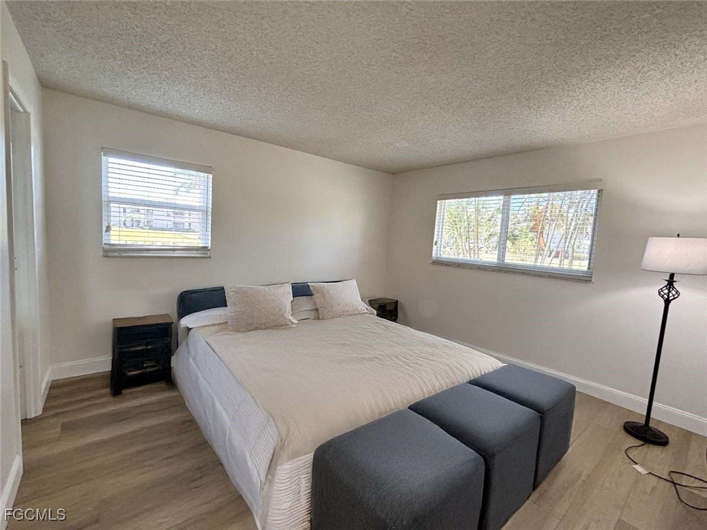 180 Turtle Lake Court, Unit 101 Naples, FL 34105 - Photo 7 of 14 a bedroom with a bed and a window
