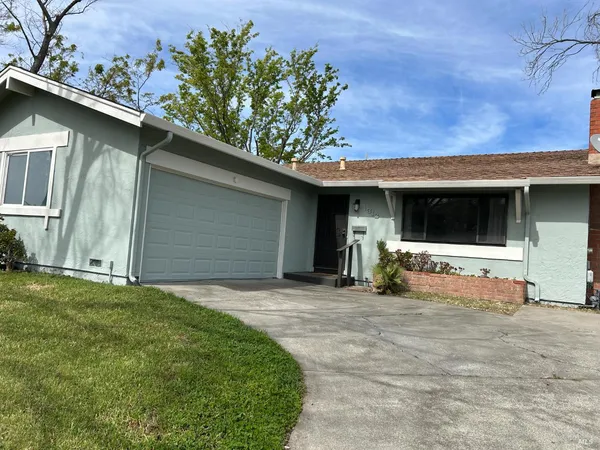 a view of a house with a yard and potted plants