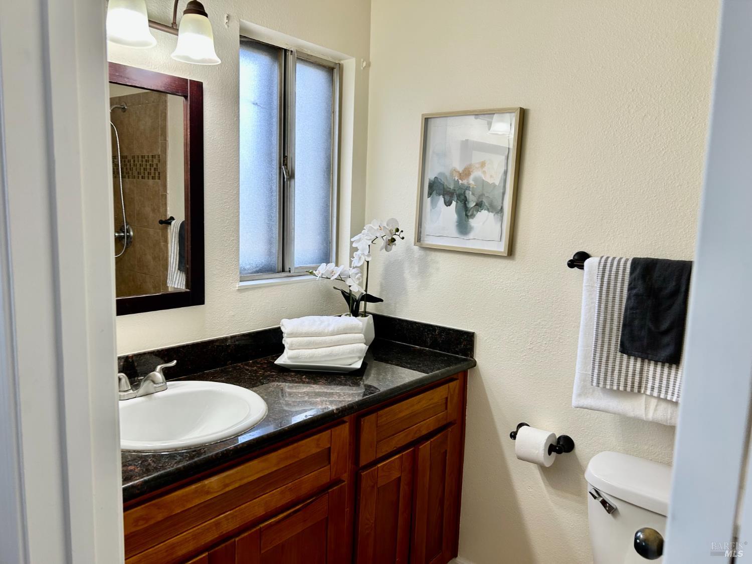1312 Sutter Court Fairfield, CA 94533 - Photo 13 of 45 a bathroom with a granite countertop sink and a mirror