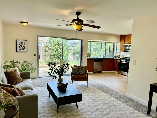 a living room with furniture ceiling fan and a window