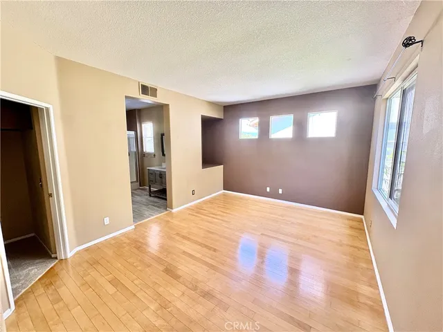 a large bedroom with a bed and a large mirror on dresser