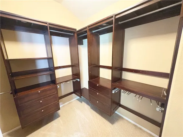 a view of walk in closet and wooden floor