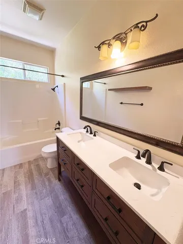 a bathroom with a double vanity sink and mirror with shower