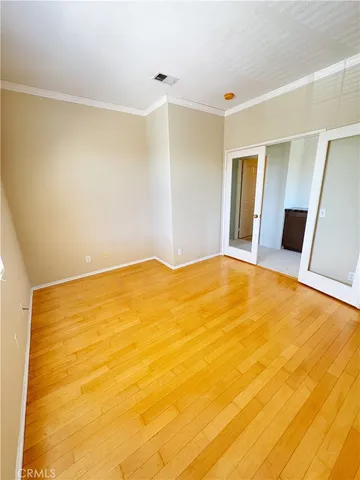 a big room with wooden floor and glass door
