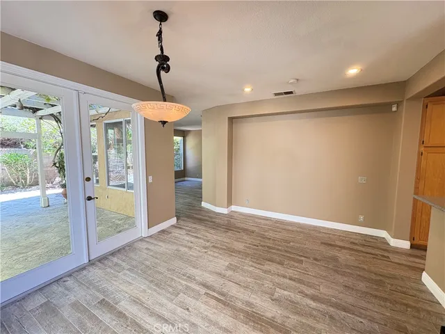 a view of a room with wooden floor fan and windows