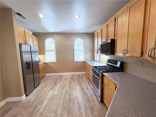 a kitchen with stainless steel appliances granite countertop a stove a sink and a refrigerator