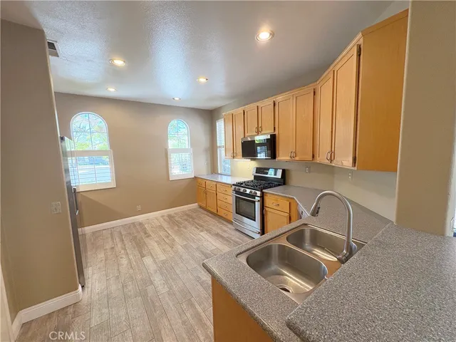 a kitchen with granite countertop a sink a stove and cabinets