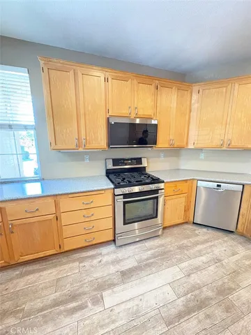 a kitchen with granite countertop a stove a sink and a microwave