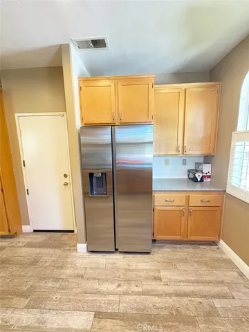 a kitchen with granite countertop a refrigerator and cabinets