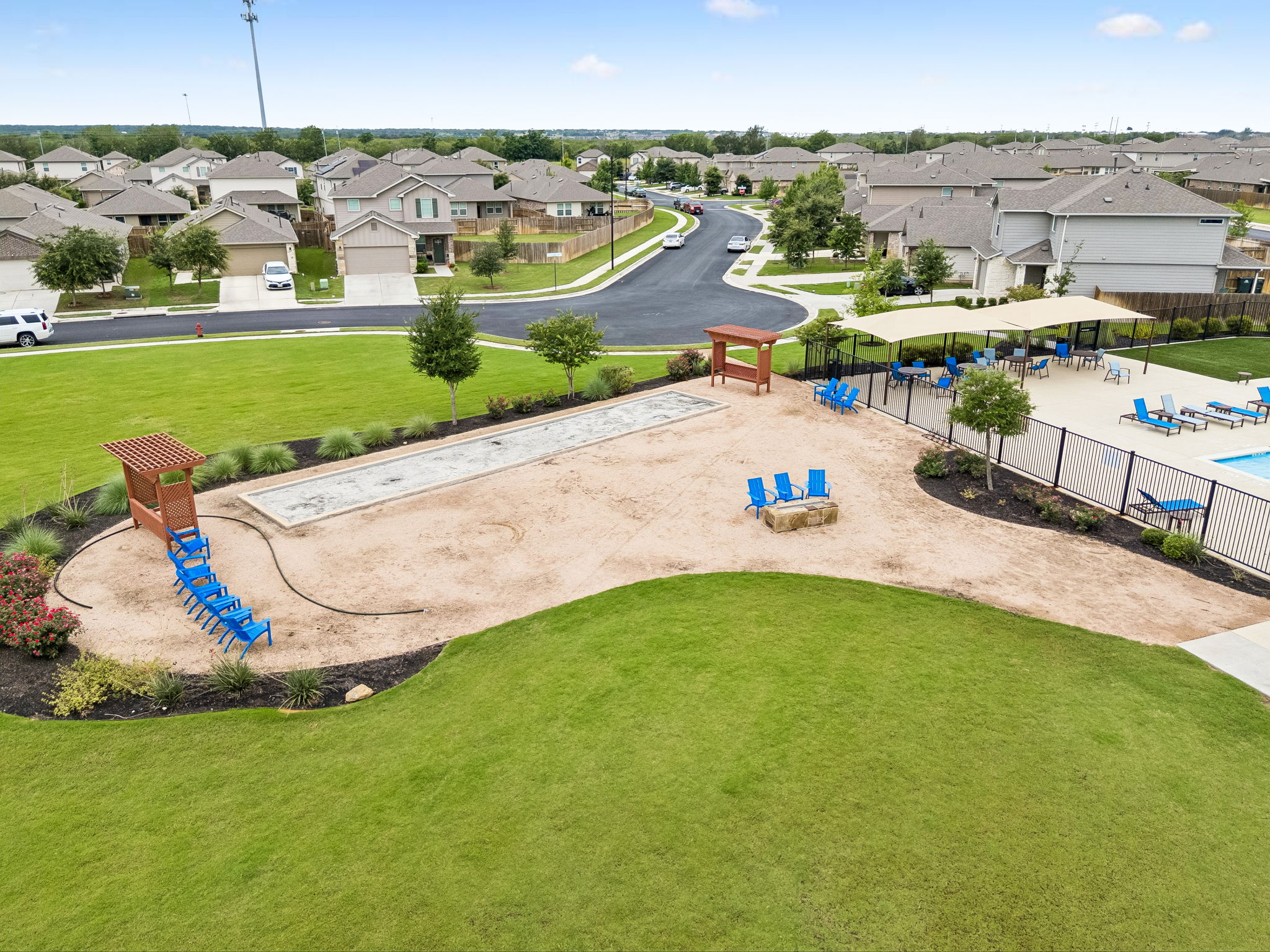 301 Rimrock Court Bastrop, TX 78602 - Photo 19 of 21 An aerial view captures the vibrant community park, complete with a bocce ball court and a serene pool area.
