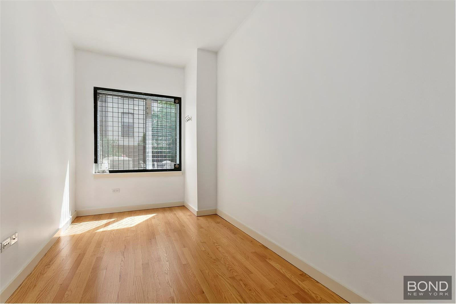 230 West 112th Street, Unit GARDEN Manhattan, NY 10026 - Photo 4 of 5 a view of an empty room with wooden floor and a window