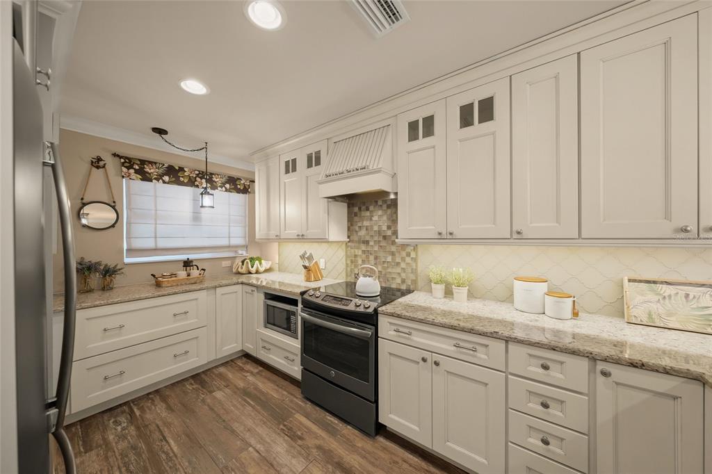4660 Ocean Boulevard, Unit O2 Sarasota, FL 34242 - Photo 17 of 55 a kitchen with white cabinets and white appliances