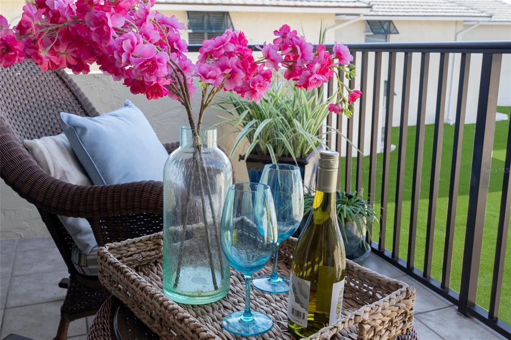 4660 Ocean Boulevard, Unit O2 Sarasota, FL 34242 - Photo 26 of 55 a vase of flowers sitting on a table with chairs