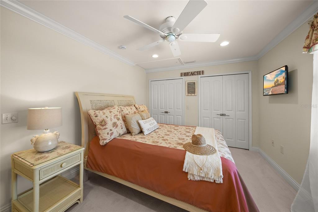 4660 Ocean Boulevard, Unit O2 Sarasota, FL 34242 - Photo 40 of 55 a bedroom with a bed and a lamp on a dresser