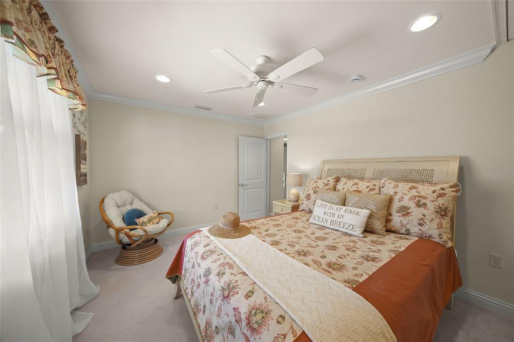 4660 Ocean Boulevard, Unit O2 Sarasota, FL 34242 - Photo 41 of 55 a bedroom with a bed and ceiling fan