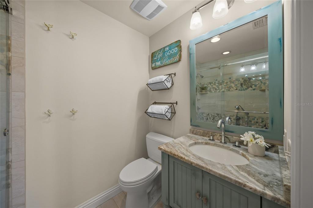 4660 Ocean Boulevard, Unit O2 Sarasota, FL 34242 - Photo 44 of 55 a bathroom with a granite countertop sink toilet and shower