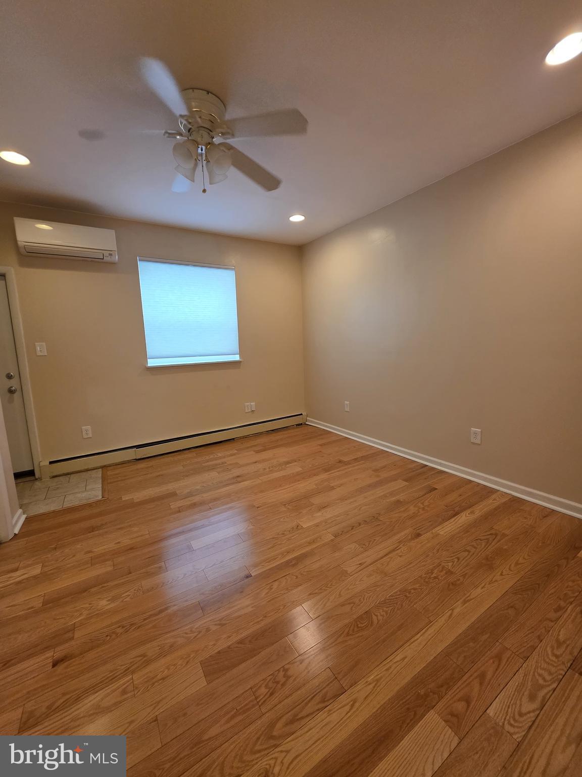 1153 South 11th Street, Unit A Philadelphia, PA 19147 - Photo 5 of 12 an empty room with wooden floor and windows
