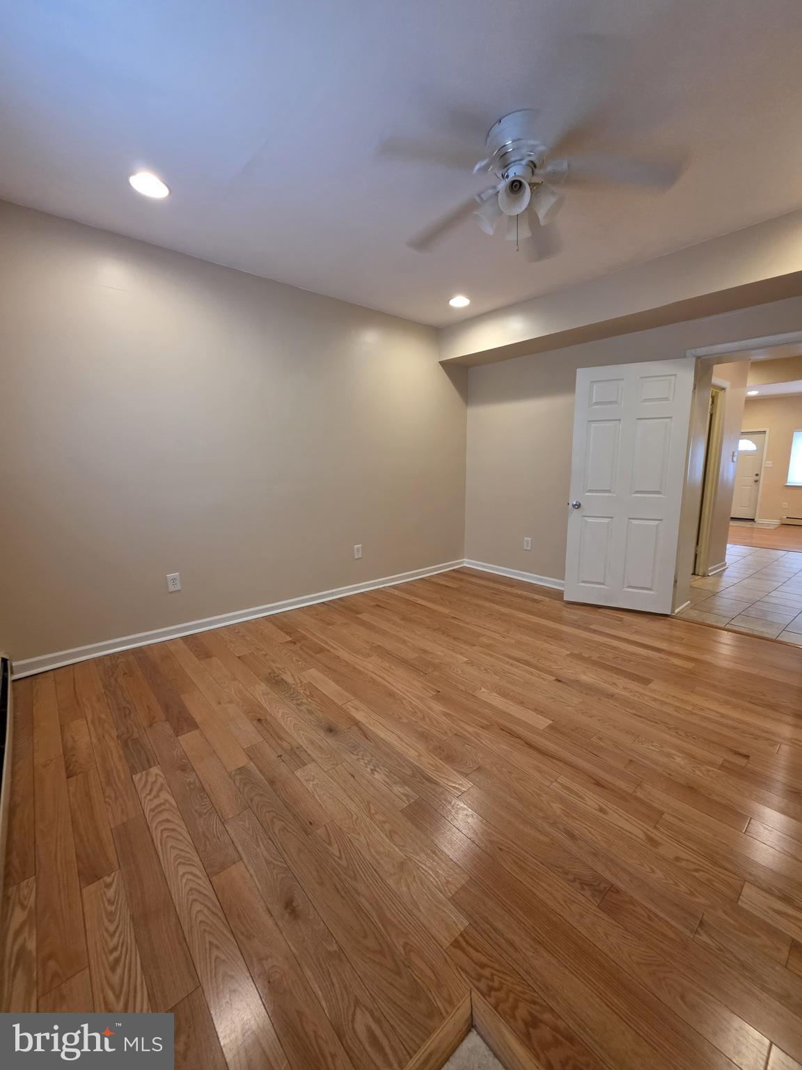 1153 South 11th Street, Unit A Philadelphia, PA 19147 - Photo 6 of 12 an empty room with wooden floor and fan