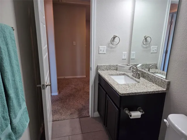 a bathroom with a granite countertop sink and a mirror