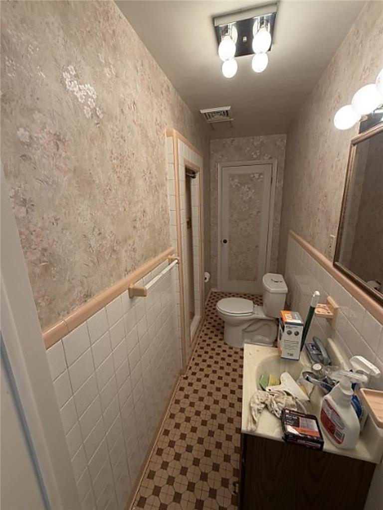 5391 Chapmans Road, Unit 1 Orefield, PA 18069 - Photo 7 of 7 A well-lit bathroom showcases patterned wallpaper and classic tiled flooring.