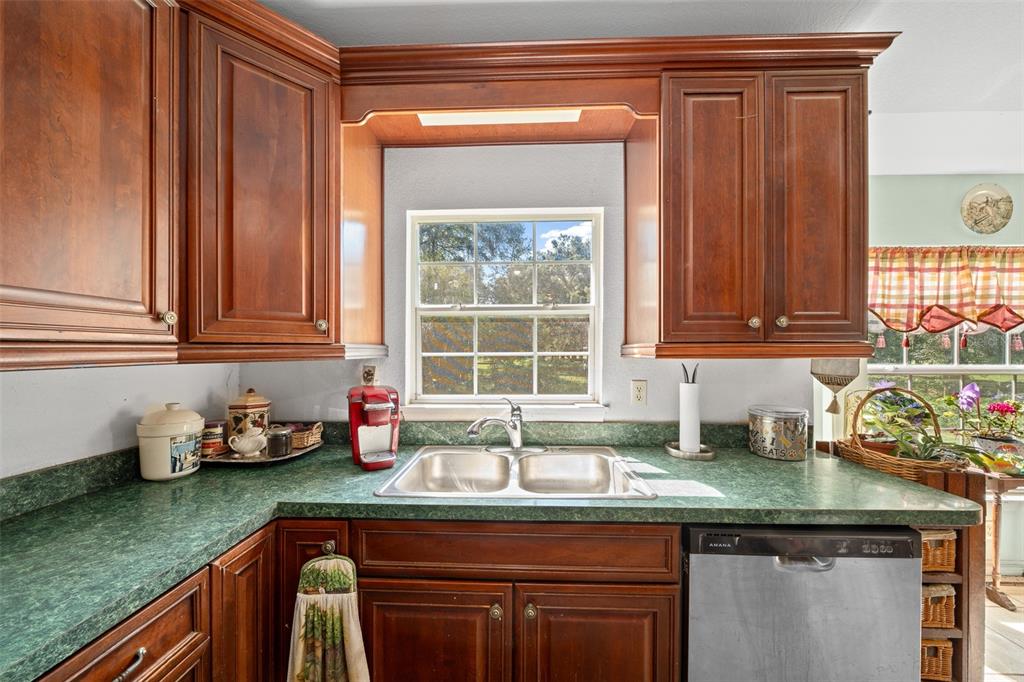 399 Northeast 155 Place Citra, FL 32113 - Photo 40 of 58 a kitchen with granite countertop a sink window and cabinets
