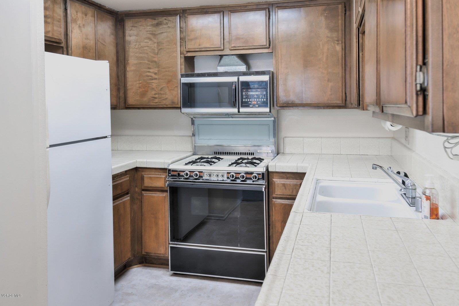 547 Spring Road, Unit 33 Moorpark, CA 93021 - Photo 12 of 28 a kitchen with granite countertop a stove and a refrigerator