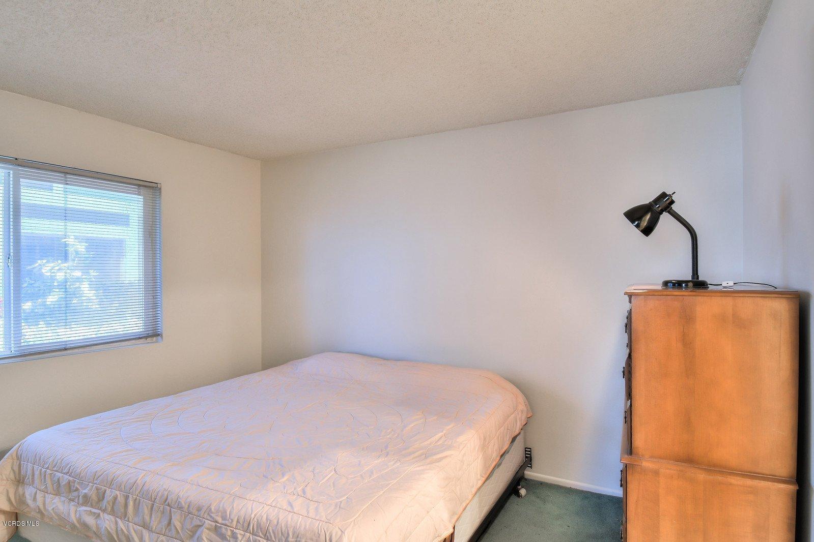 547 Spring Road, Unit 33 Moorpark, CA 93021 - Photo 16 of 28 a bedroom with a bed and a refrigerator