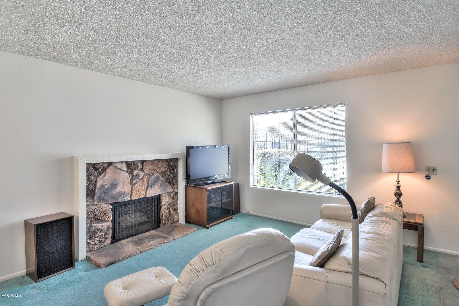 547 Spring Road, Unit 33 Moorpark, CA 93021 - Photo 8 of 28 a living room with furniture a fireplace and a flat screen tv