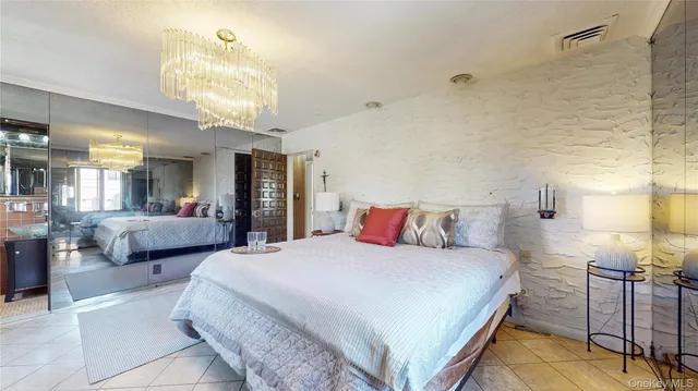 a bedroom with a large bed and a chandelier