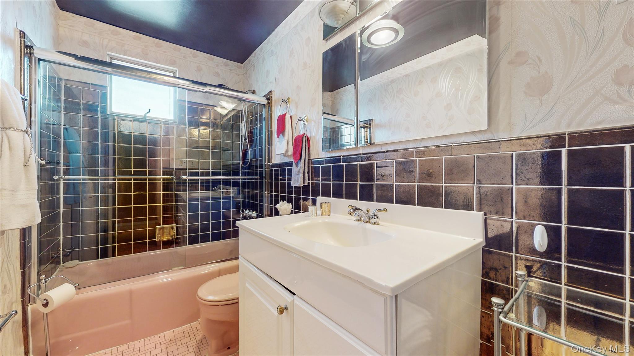 52-04 Redfield Street Queens, NY 11362 - Photo 17 of 25 Full bathroom with tile walls, toilet, vanity, and bath / shower combo with glass door