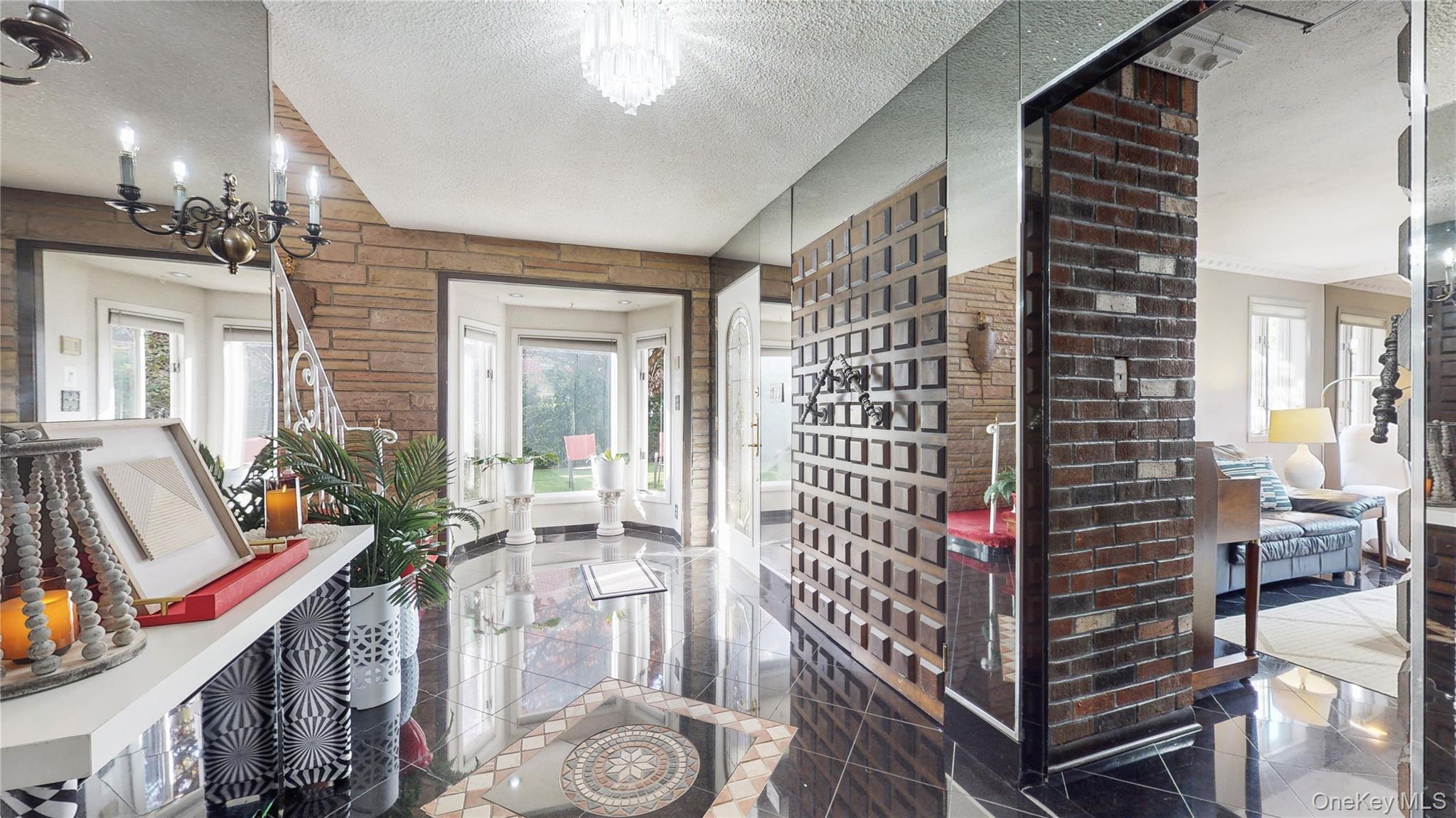52-04 Redfield Street Queens, NY 11362 - Photo 20 of 25 Hall with a chandelier, a textured ceiling, healthy amount of natural light, and granite floors