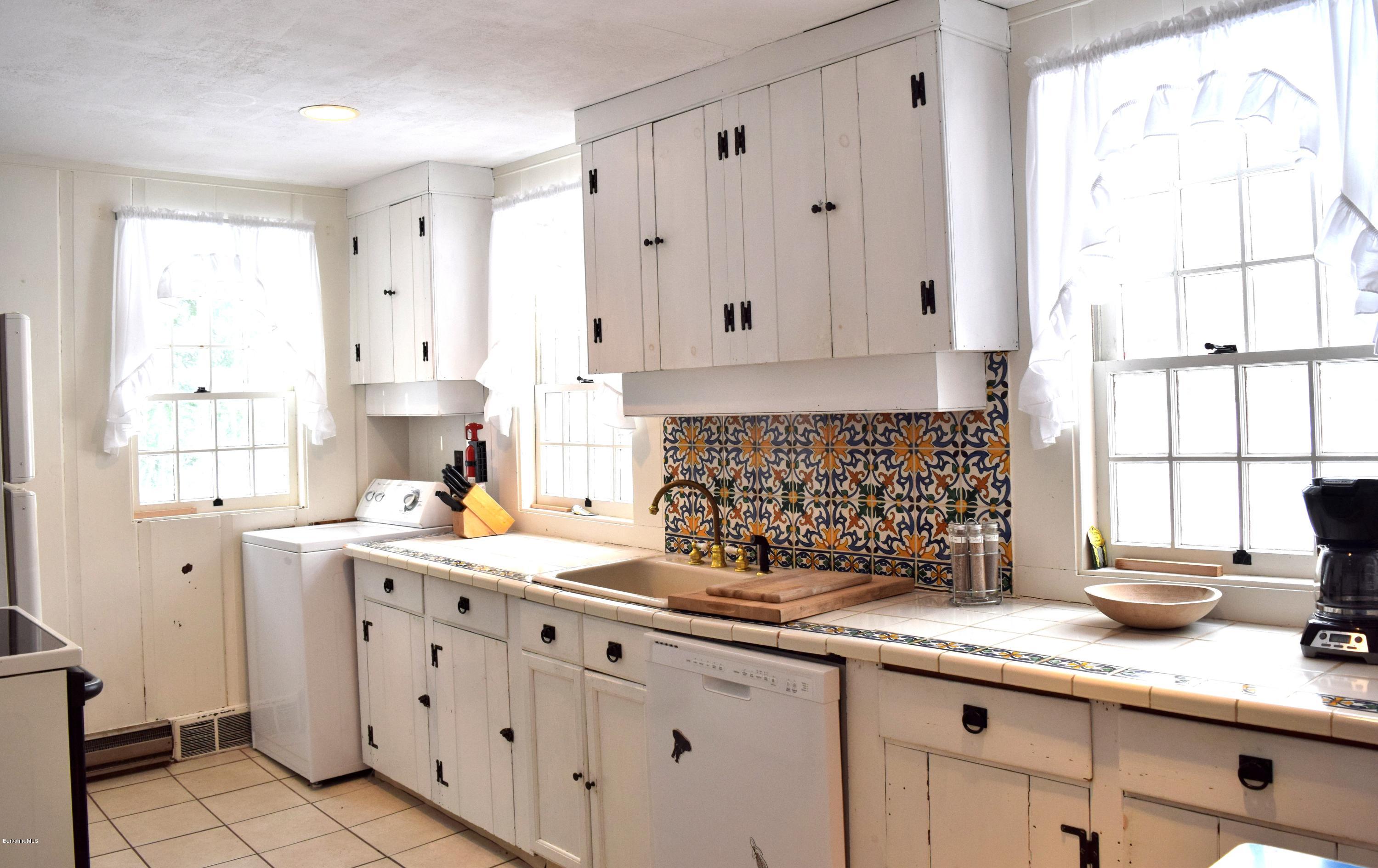 246 Judd Road Otis, MA 01253 - Photo 5 of 21 a kitchen with granite countertop a sink white cabinets and a window
