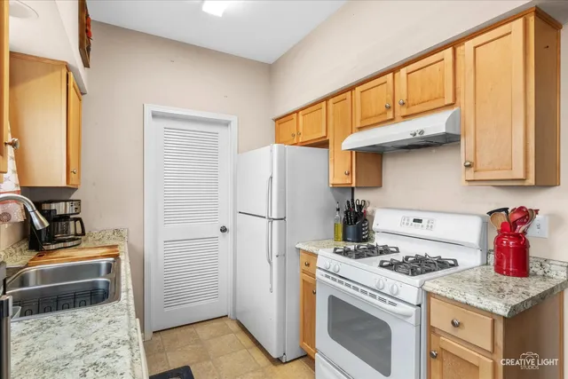 a kitchen with stainless steel appliances granite countertop a stove a refrigerator and a sink