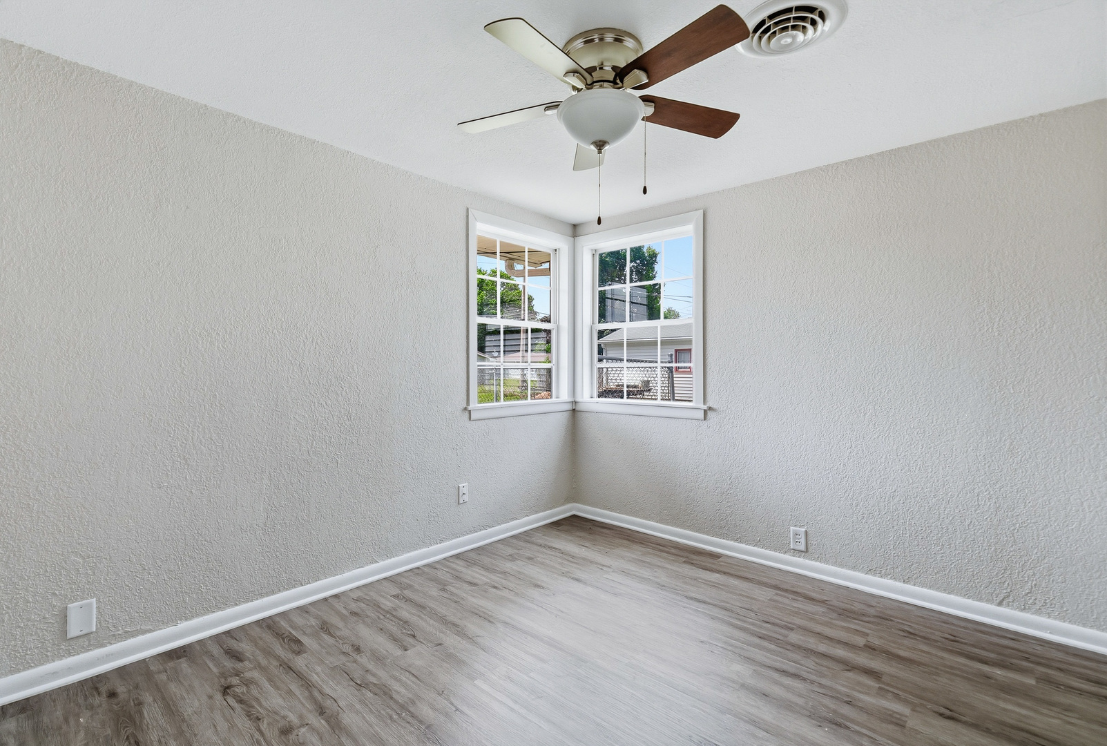 2306 9th Street Silvis, IL 61282 - Photo 22 of 32 an empty room with wooden floor ceiling fan and windows