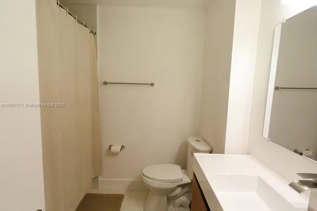 a white toilet sitting next to a bathroom sink