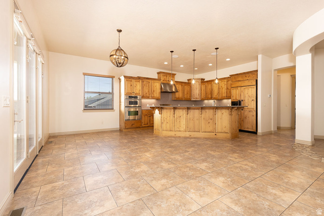 888 East Fiddlers Canyon Road Cedar City, UT 84721 - Photo 13 of 74 Kitchen featuring a kitchen island with sink, paneled built in fridge, stainless steel double oven, dark countertops, and wood finish cabinets