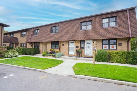 front view of a brick house with a yard